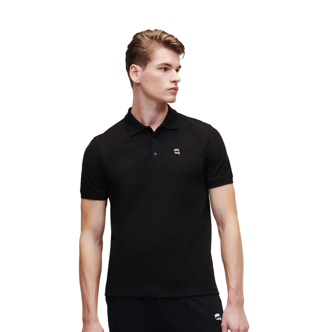 A side-profile view of a model looking away, wearing a fitted black short-sleeve Karl Lagerfeld polo shirt featuring a ribbed collar and a small embroidered chest logo.