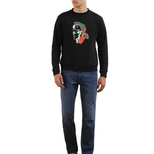A male model wearing a black Karl Lagerfeld sweatshirt with a colorful graphic print on the front, paired with blue jeans.