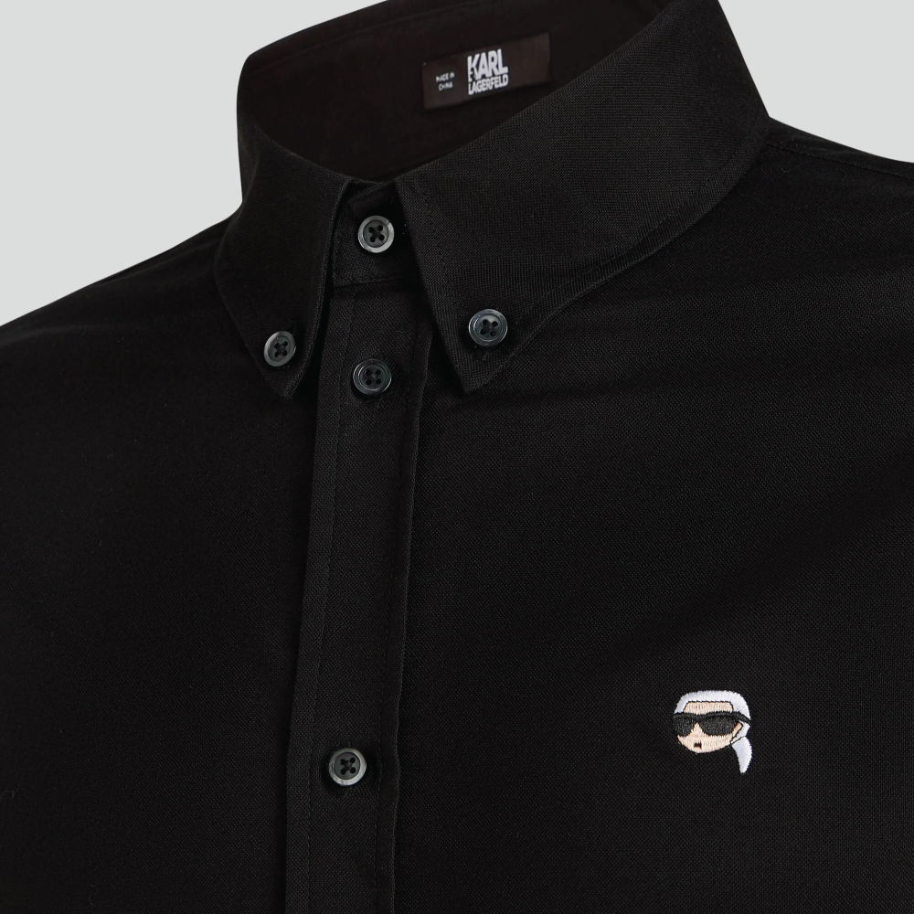 A front view of a model wearing a crisp black long-sleeve Karl Lagerfeld Ikon Poplin Shirt with a button-down collar and small embroidered chest logo.