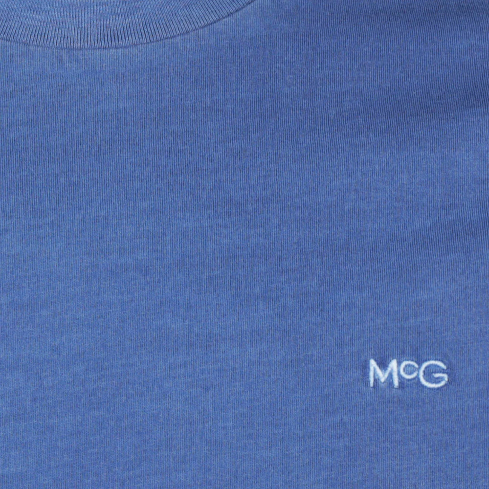 Front view of a McGregor men's garment dyed crew neck T-shirt in vintage blue with short sleeves and embroidered chest logo on a white background.