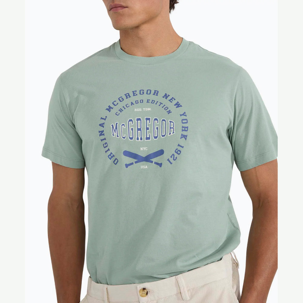 Man wearing a McGregor men's Ice green Original Print crew neck T-shirt with a vintage logo graphic and short sleeves, Kayagan