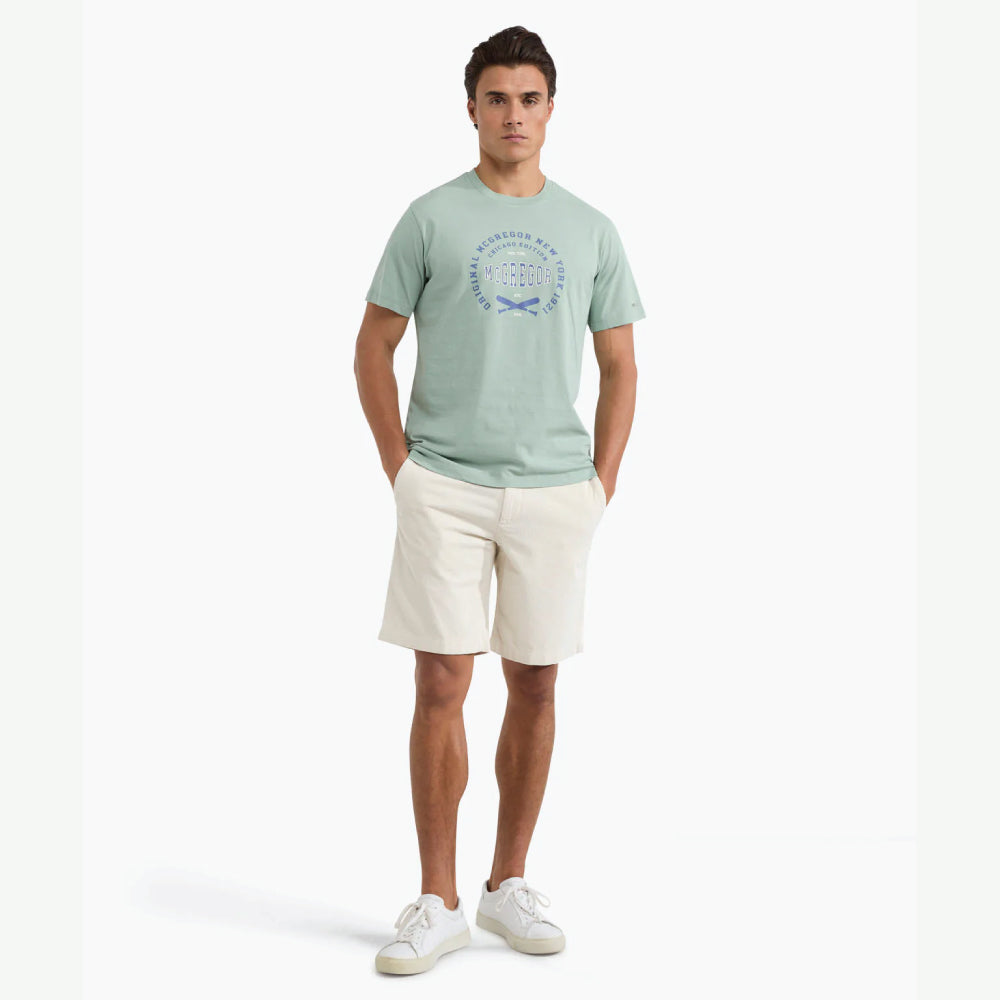 Man wearing a McGregor men's Ice green Original Print crew neck T-shirt with a vintage logo graphic and short sleeves, Kayagan