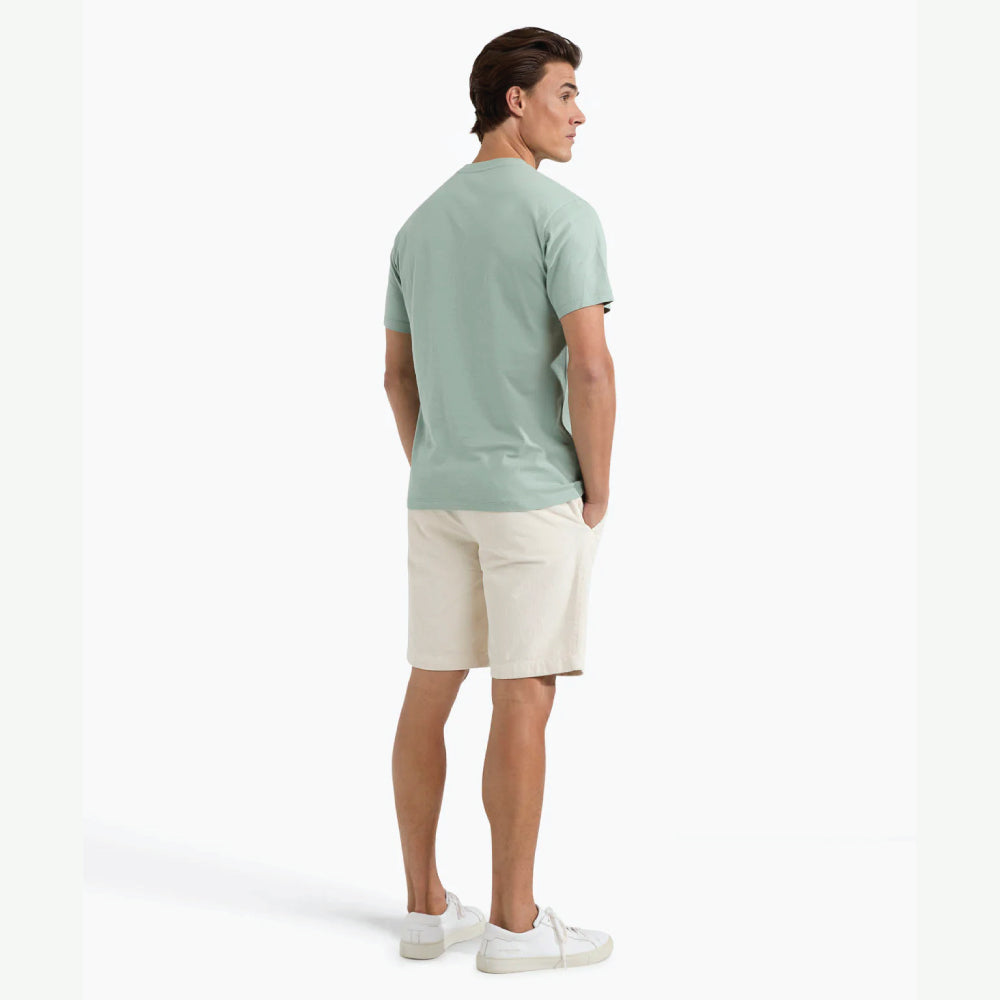 Man wearing a McGregor men's Ice green Original Print crew neck T-shirt with a vintage logo graphic and short sleeves, Kayagan