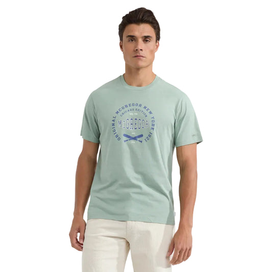 Man wearing a McGregor men's Ice green Original Print crew neck T-shirt with a vintage logo graphic and short sleeves, Kayagan