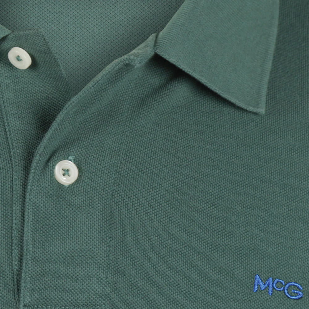 Model wearing a McGregor men's classic regular fit dark green polo shirt with a ribbed collar and short sleeves on a white background.
