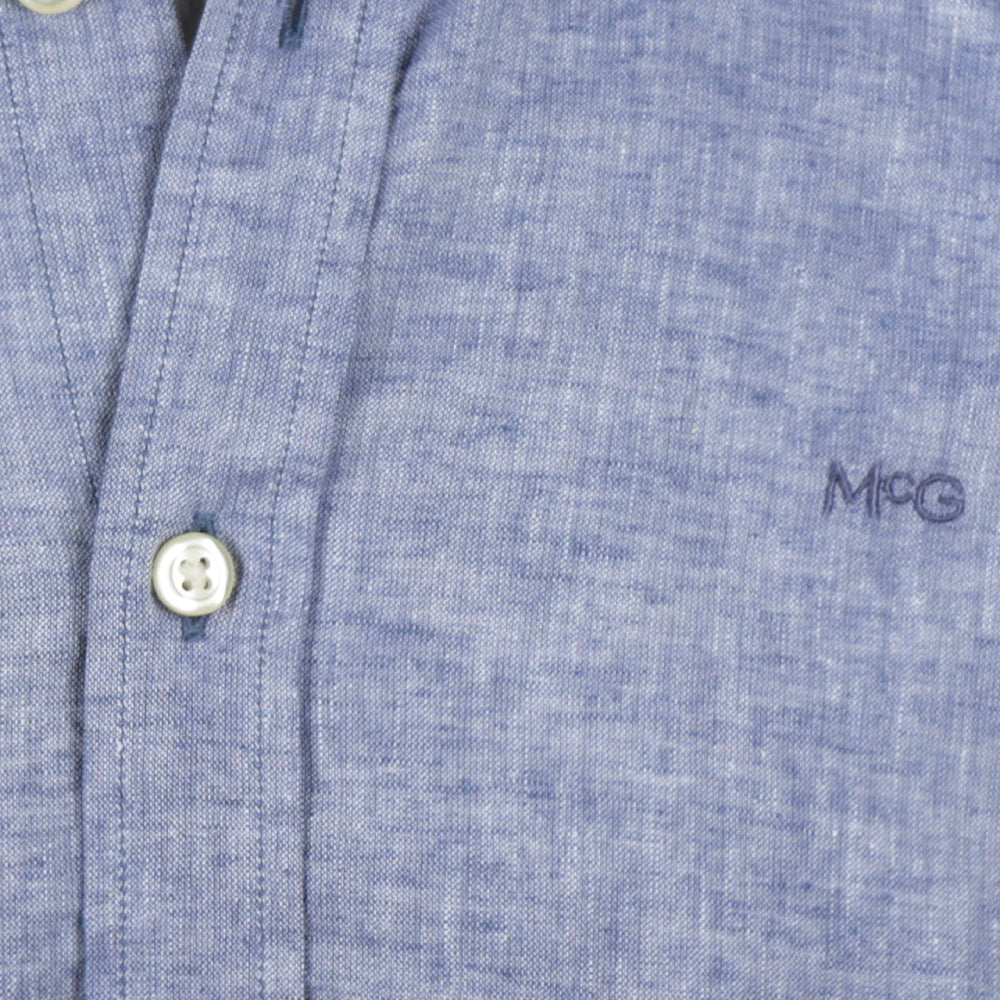Model wearing a McGregor men's blue linen cotton button-down shirt with long sleeves and a classic collar on a white background.