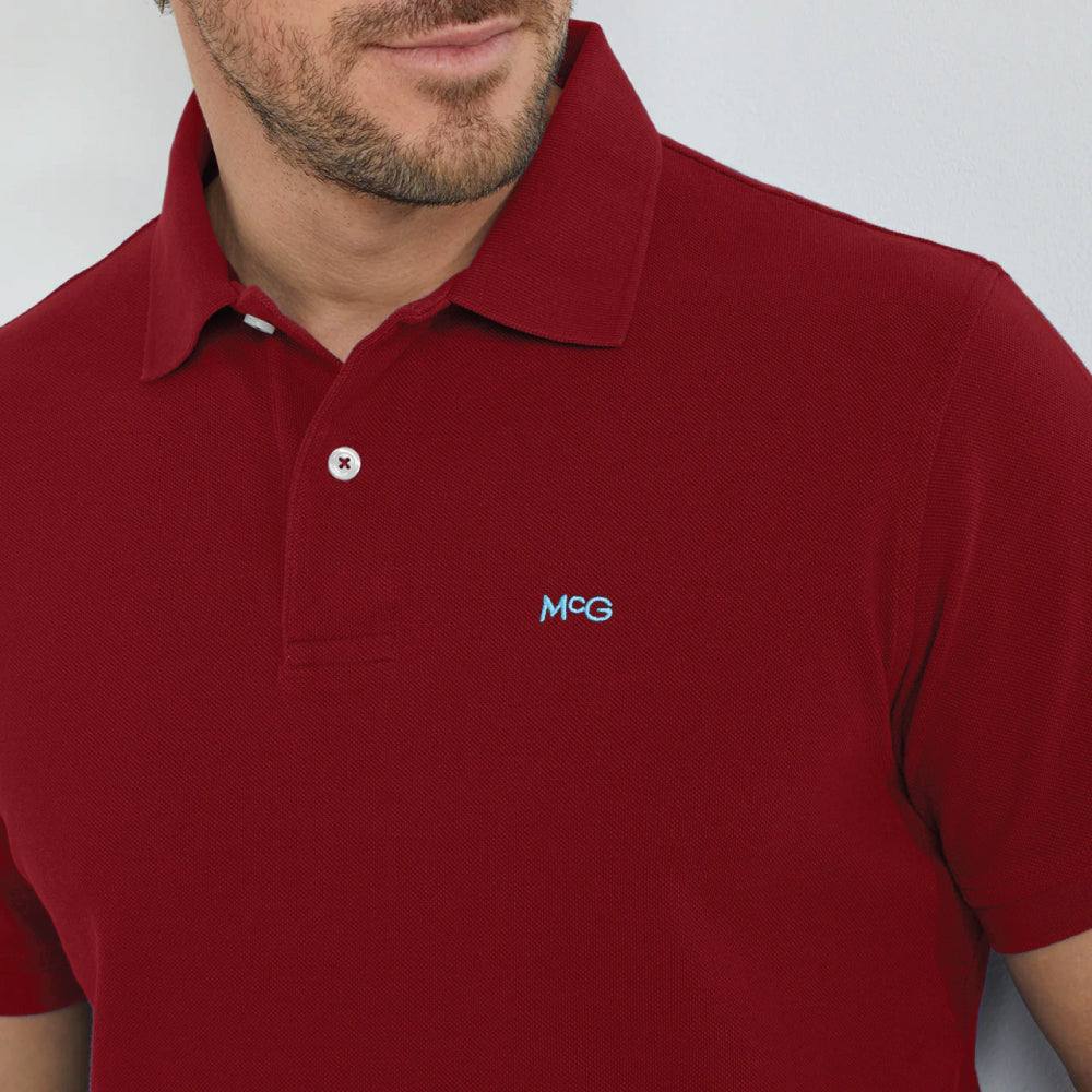 Model wearing a McGregor men's classic regular fit dark red polo shirt with a ribbed collar and short sleeves on a white background.