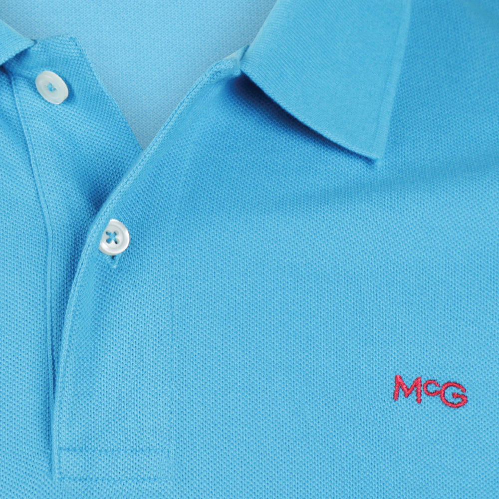 A sea blue colored polo shirt with a collar, buttons, and the McGregor logo embroidered on the chest.
