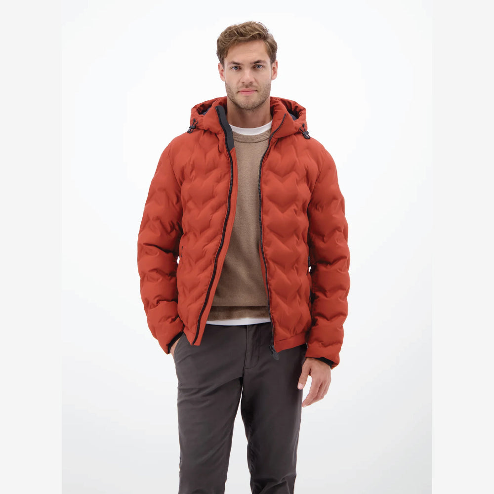 Man wearing a rust, burnt red Lerros quilted jacket with hood, styled with grey trousers, front view studio photo