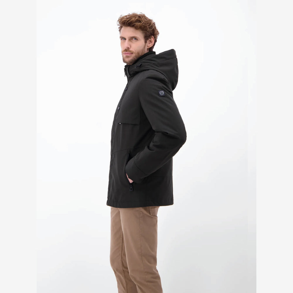 Man wearing a black Lerros structured blouson jacket with hood, styled with beige chinos, front view studio photo, at Kayagan