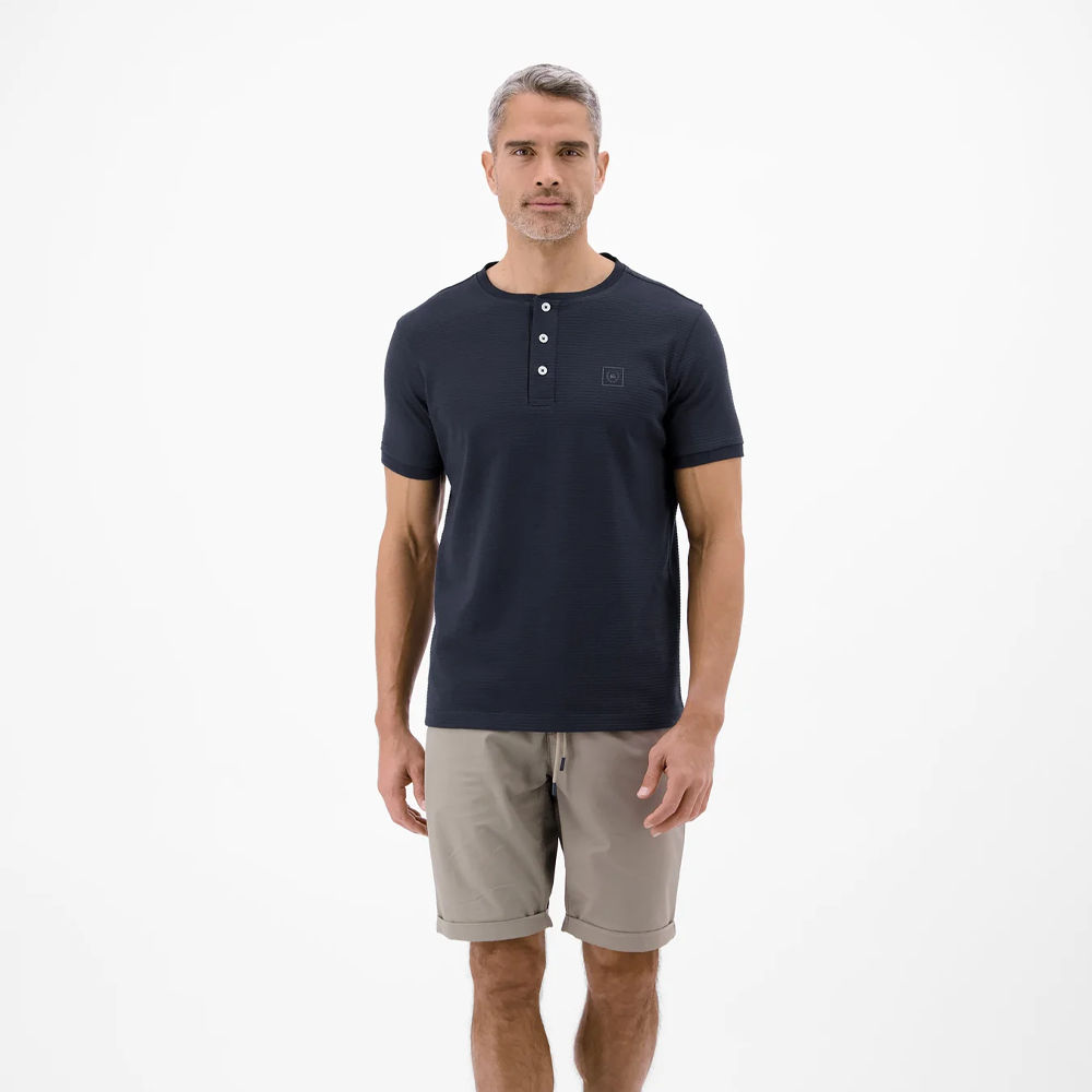 Man wearing a navy Lerros t-shirt with round collar, button placket, and Cool and Dry fabric, front view studio photo, available at ayagan
