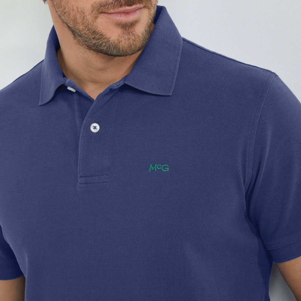 Model wearing a McGregor men's classic regular fit navy blue polo shirt with a ribbed collar and short sleeves on a white background.