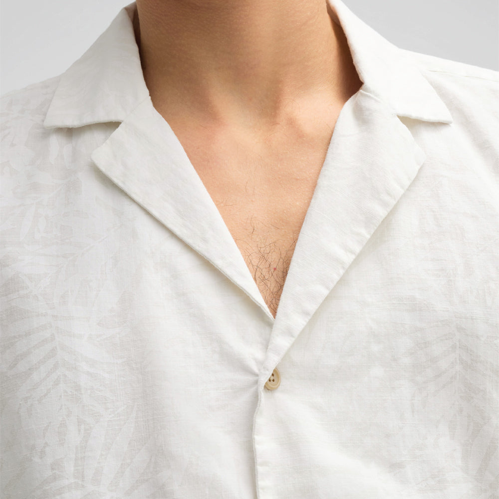 Man wearing Strellson Cliro ecru short-sleeved shirt with tonal palm leaf pattern and camp collar